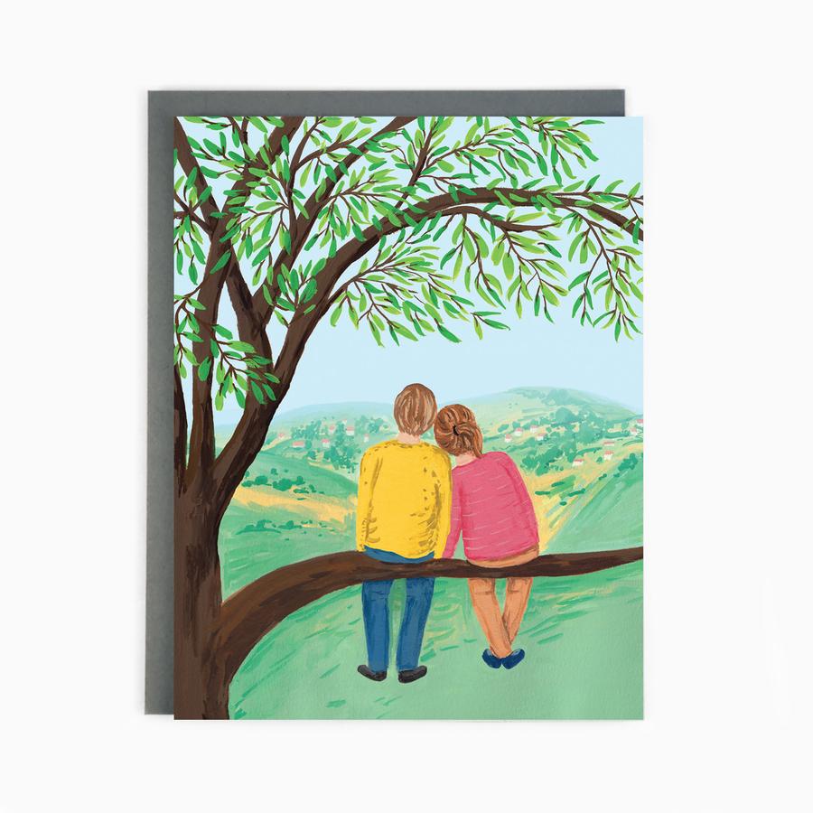 Couple in a tree looking at the hills
